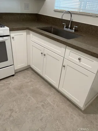 a close view of a sink and dishwasher with cabinets