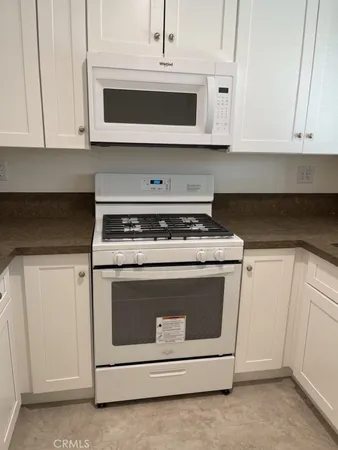 a stove top oven sitting inside of a kitchen