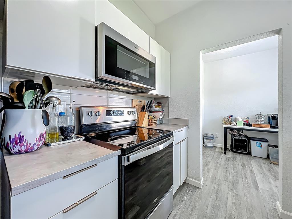 7033 Lakner Way Orlando, FL 32822 - Photo 11 of 31 a kitchen with stainless steel appliances a stove microwave and cabinets