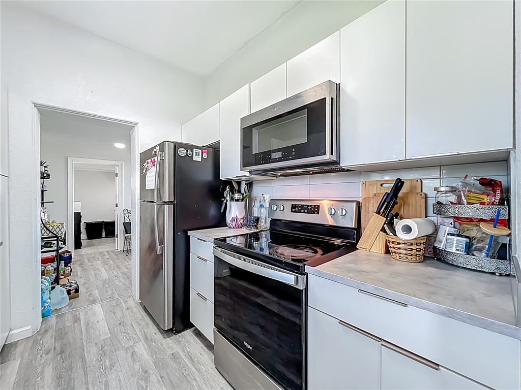 7033 Lakner Way Orlando, FL 32822 - Photo 12 of 31 a kitchen with a stove microwave and refrigerator