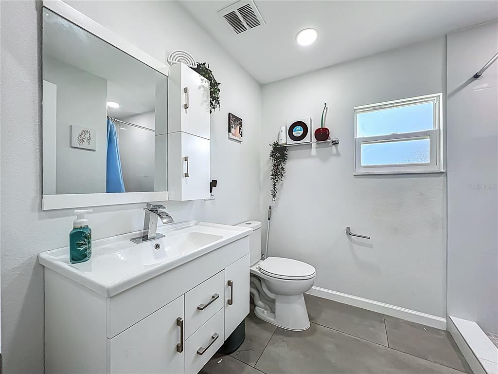 7033 Lakner Way Orlando, FL 32822 - Photo 20 of 31 a bathroom with a toilet sink and mirror
