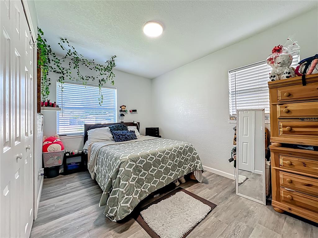 7033 Lakner Way Orlando, FL 32822 - Photo 24 of 31 a bedroom with a bed and wooden floor