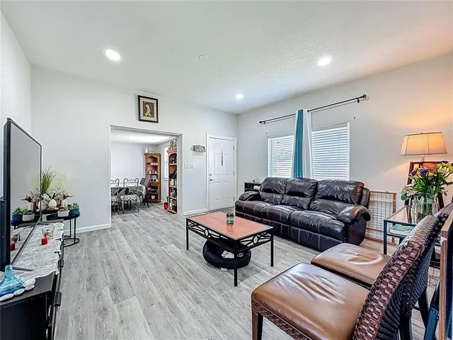 a living room with furniture and wooden floor