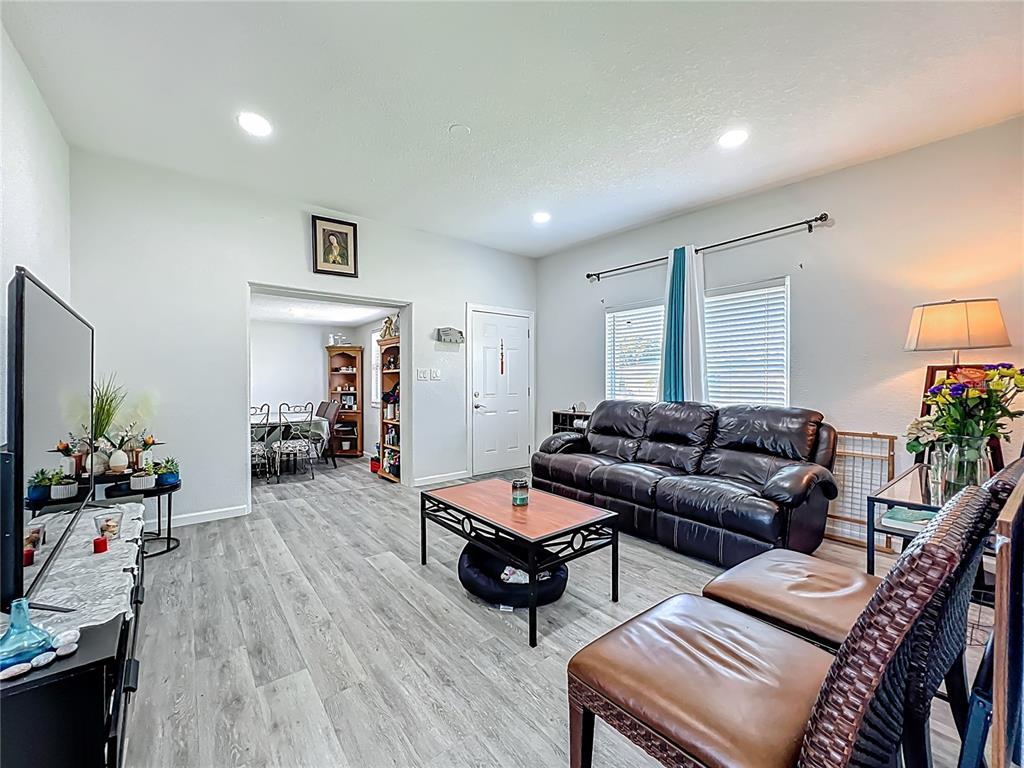 7033 Lakner Way Orlando, FL 32822 - Photo 7 of 31 a living room with furniture and wooden floor