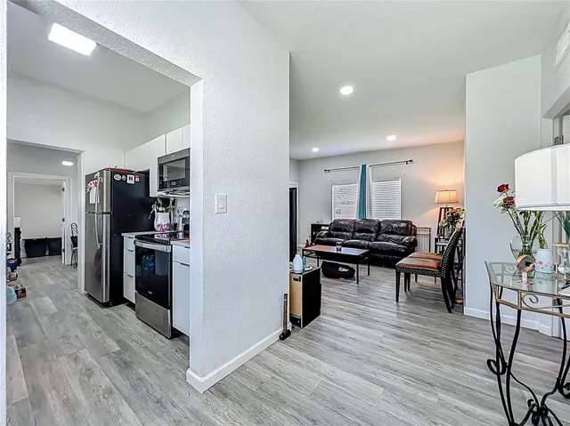a kitchen with stainless steel appliances kitchen island hardwood floor and a table