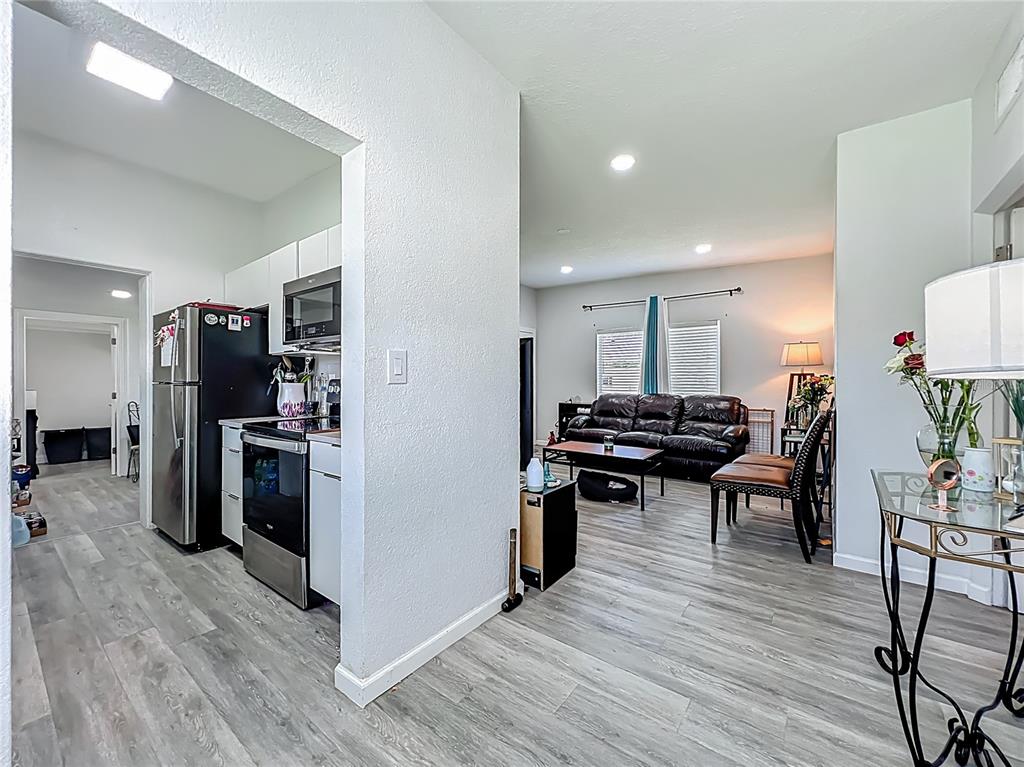 7033 Lakner Way Orlando, FL 32822 - Photo 8 of 31 a kitchen with stainless steel appliances kitchen island hardwood floor and a table