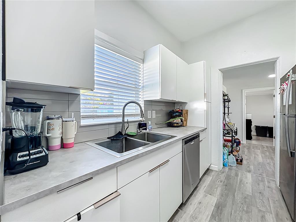 7033 Lakner Way Orlando, FL 32822 - Photo 10 of 31 a kitchen with sink a stove and cabinets