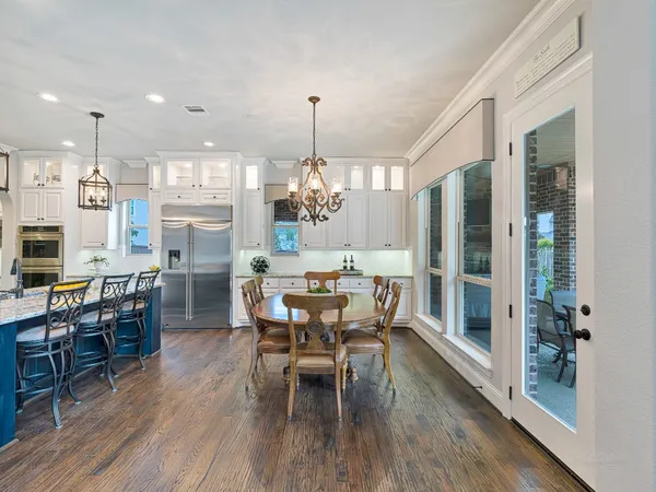 a dining room with furniture a chandelier and wooden floor