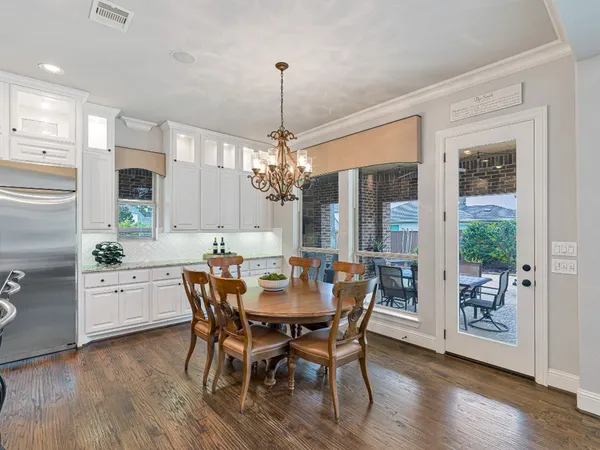 a dining room with furniture a chandelier and wooden floor