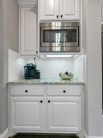 a kitchen with white cabinets and appliances