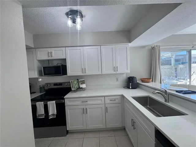 a kitchen with a table chairs a stove and a refrigerator
