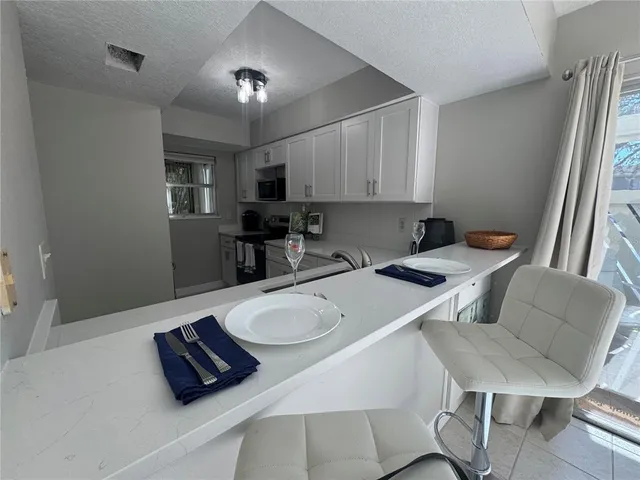 a kitchen with white cabinets and black appliances