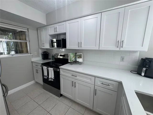 a kitchen with stainless steel appliances a refrigerator sink and microwave