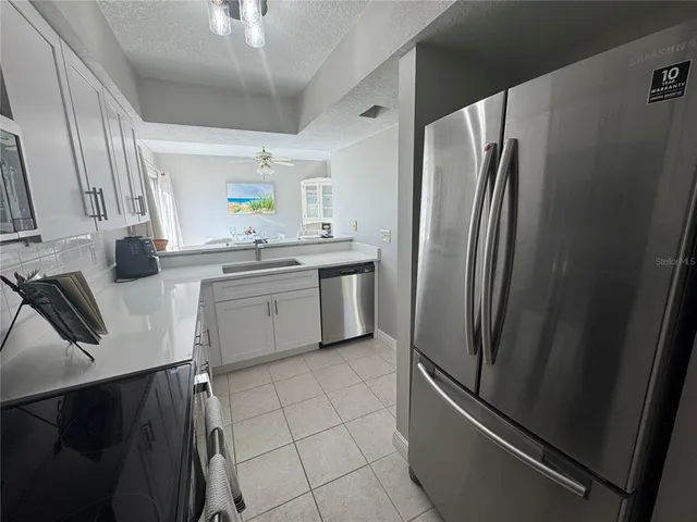 a kitchen with stainless steel appliances granite countertop a refrigerator sink and stove
