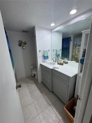 a bathroom with a granite countertop sink a toilet and a shower