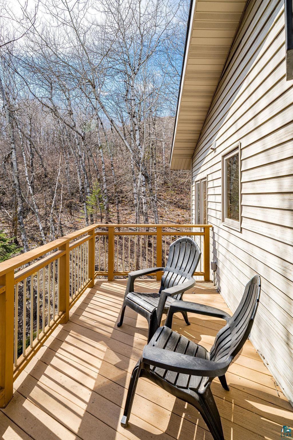 4856 Kingston Street Duluth, MN 55804 - Photo 54 of 88 Expansive wooden deck featuring sturdy wood railings and composite decking, offering an open-air extension of the home with a wooded backdrop
