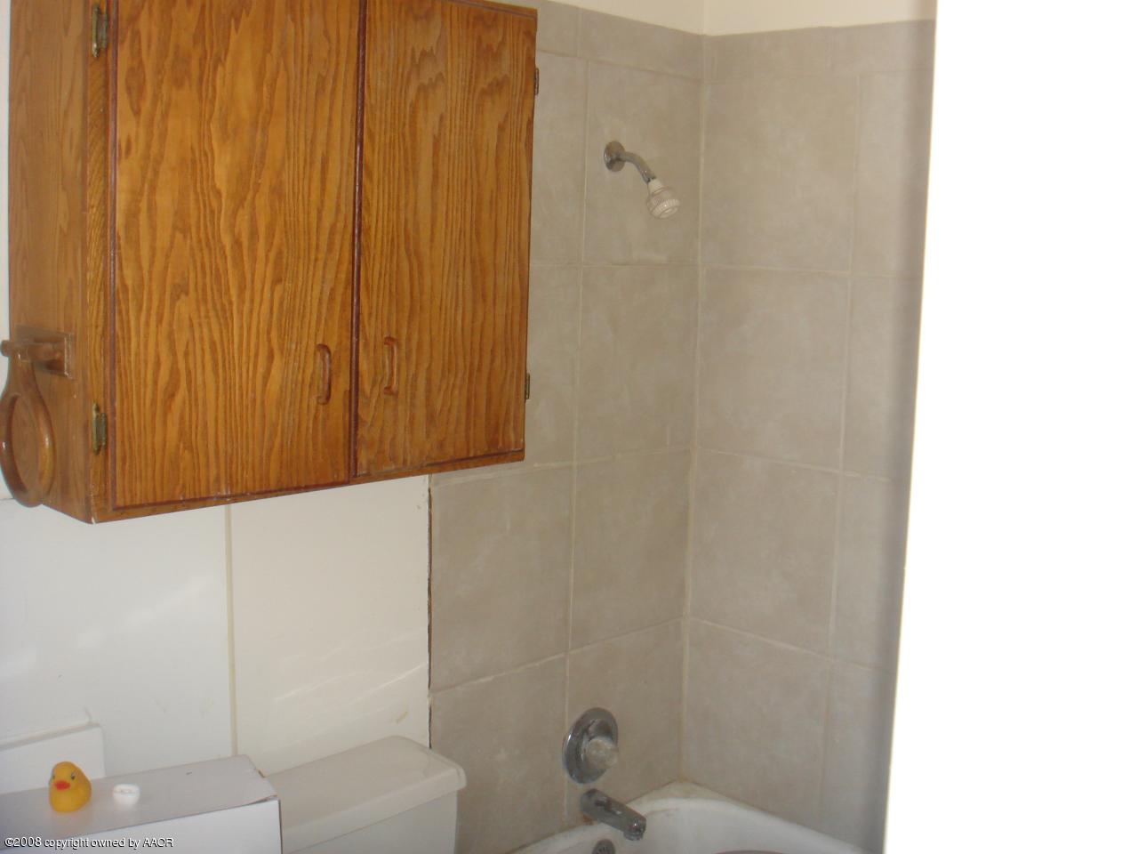 4300 South Hayden Street Amarillo, TX 79110 - Photo 8 of 10 a bathroom with a shower curtain and a sink