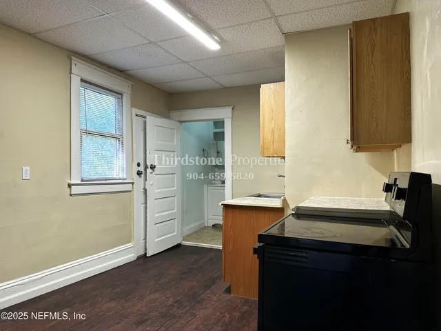 a kitchen with a sink cabinets and wooden floor