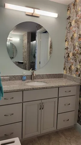 a bathroom with a granite countertop sink and a mirror