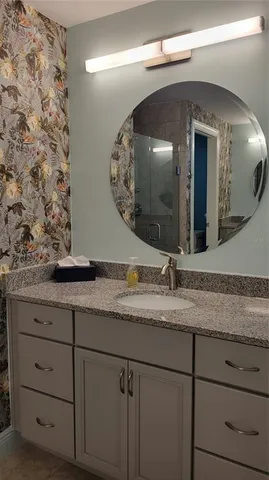 a bathroom with a granite countertop sink and a mirror