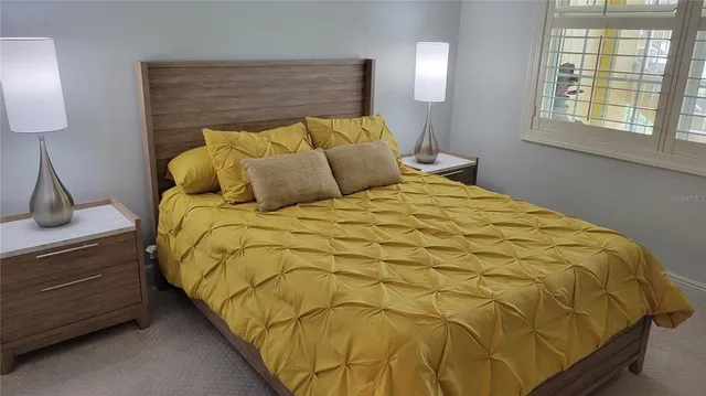 a bed sitting in a bedroom next to a window