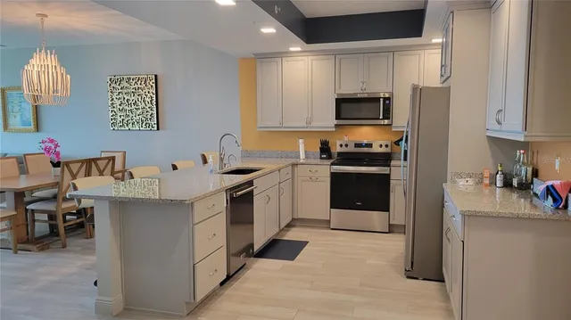 a kitchen with stainless steel appliances a stove refrigerator sink and microwave
