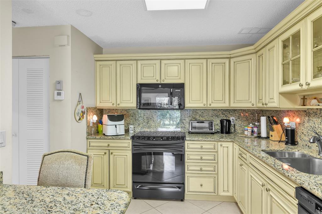 6693 Via Regina, Unit 6693 Boca Raton, FL 33433 - Photo 18 of 27 a kitchen with stainless steel appliances granite countertop a stove and a sink