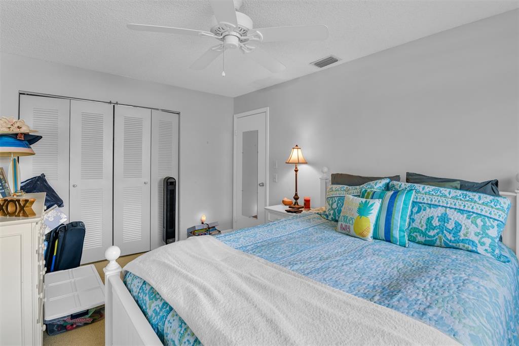 6693 Via Regina, Unit 6693 Boca Raton, FL 33433 - Photo 27 of 27 a bedroom with a bed and a chandelier