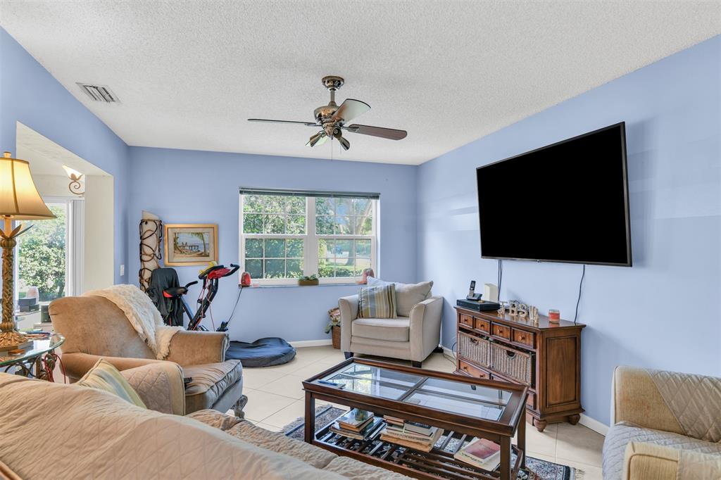 6693 Via Regina, Unit 6693 Boca Raton, FL 33433 - Photo 9 of 27 a living room with furniture and a flat screen tv