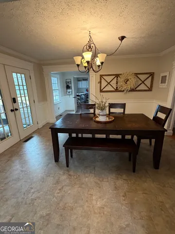 a room with table chairs and wooden floor