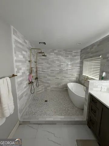 a bathroom with a granite countertop sink a toilet a mirror and shower