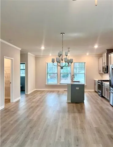 a view of a room with wooden floor and kitchen