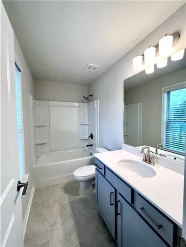 a bathroom with a sink a toilet a mirror and bathtub