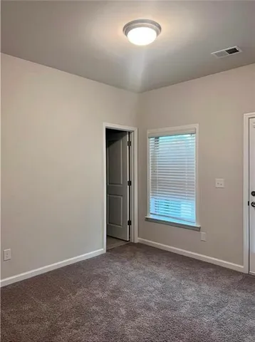 an empty room with windows and closet
