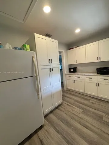a kitchen with granite countertop white cabinets and white stainless steel appliances