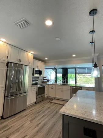 a kitchen with kitchen island a counter top space appliances and cabinets