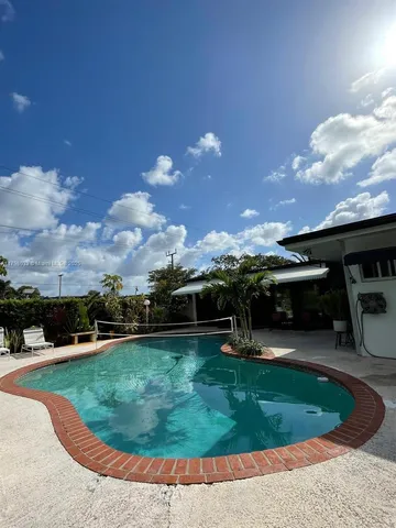 a view of a swimming pool with a yard and plants