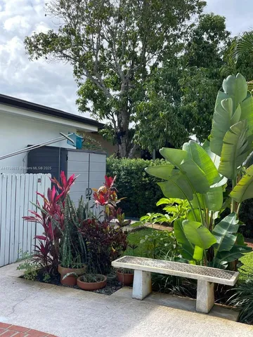 a front view of a house with a yard and a garden