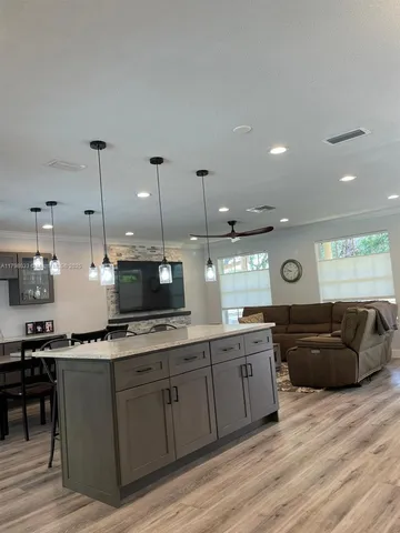 a large kitchen with stainless steel appliances kitchen island granite countertop a stove a sink and a microwave