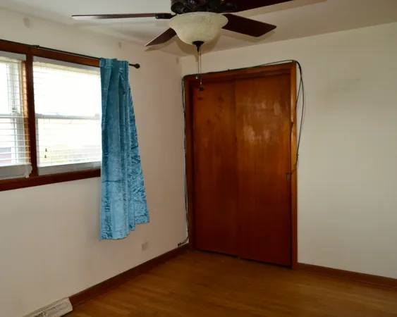 an empty room with window and wooden floor