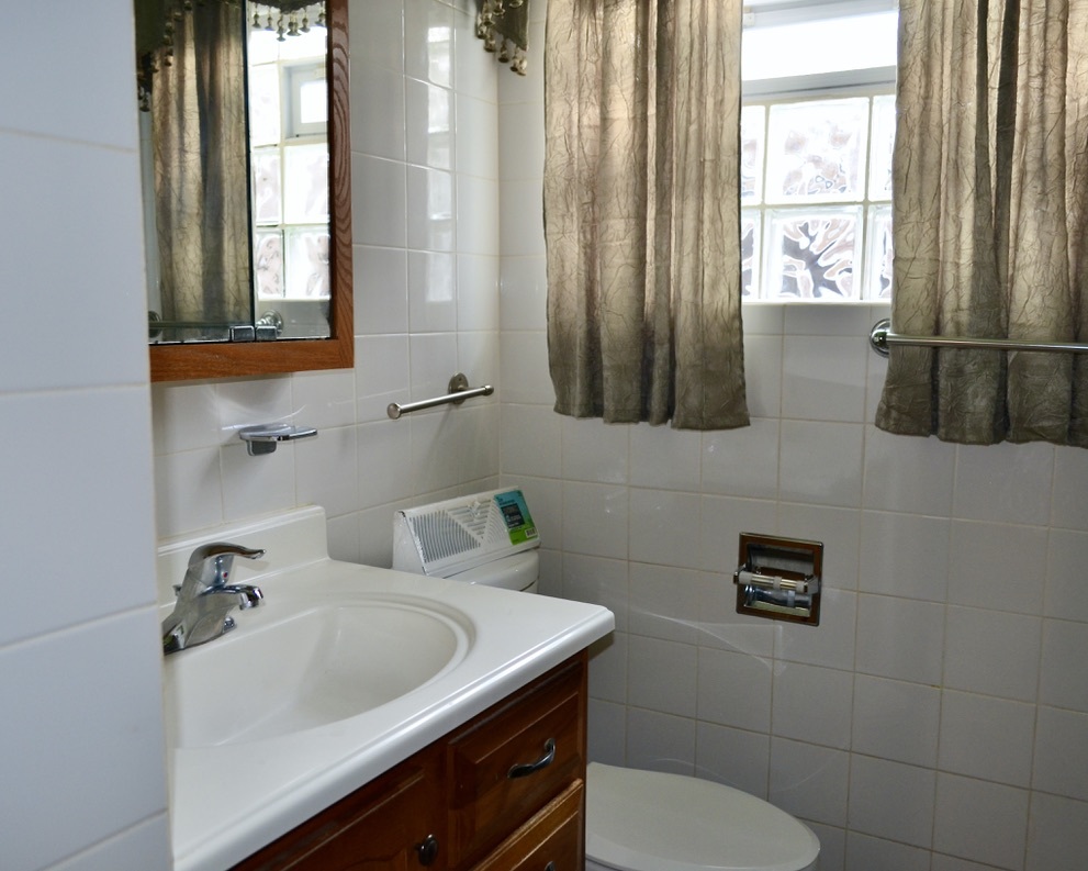 9238 South Normal Avenue Chicago, IL 60620 - Photo 10 of 13 a bathroom with a sink a toilet and a mirror