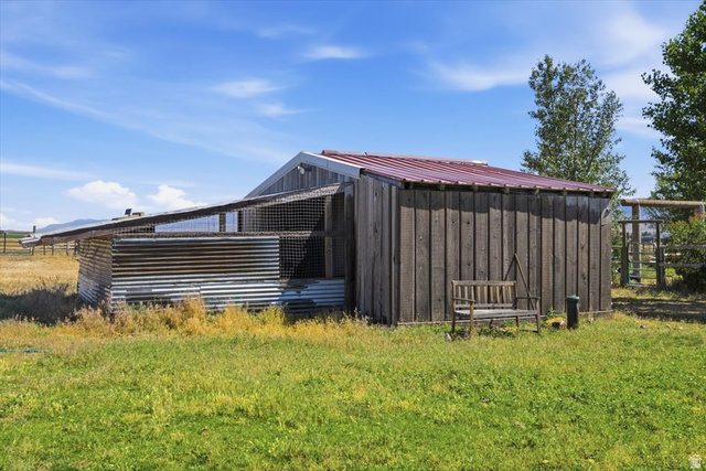 1634 West Arimo Road Arimo, ID 83214 - Photo 53 of 89 Outbuilding featuring a red metal roof, vertical wood siding, and corrugated metal panels