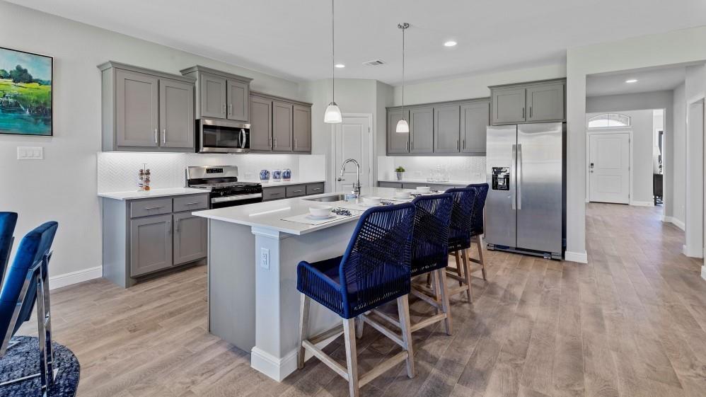 111 Stanton Avenue Rhome, TX 76078 - Photo 28 of 30 a kitchen with stainless steel appliances granite countertop a stove a refrigerator a sink a microwave and chairs