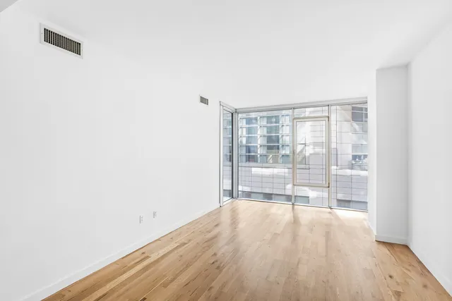 a view of empty room with wooden floor