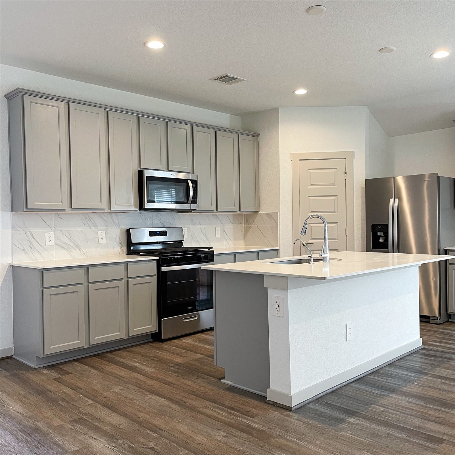 6814 Bradford Terrace Road Richmond, TX 77407 - Photo 11 of 31 a kitchen with stainless steel appliances granite countertop a stove top oven a sink and a microwave