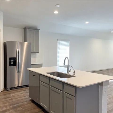 a kitchen with stainless steel appliances granite countertop a sink a stove a refrigerator and cabinets