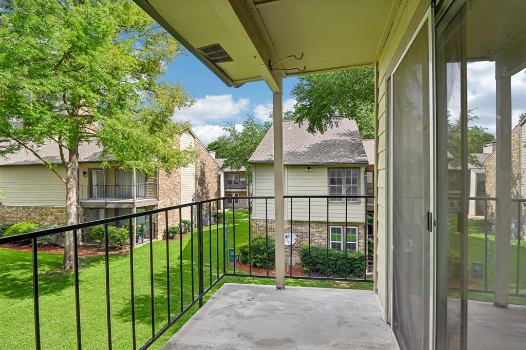 5300 Keller Springs Road, Unit 2055 Dallas, TX 75248 - Photo 20 of 24 Private outdoor balcony featuring a concrete floor, black metal railing, and a sliding glass door with an integrated screen
