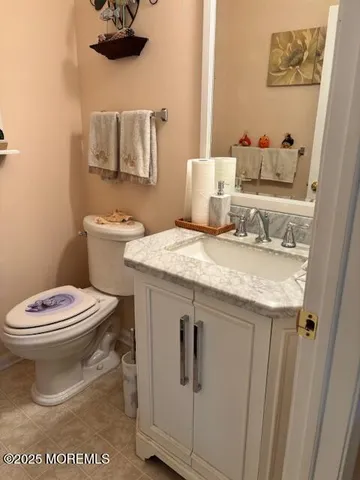 a bathroom with a granite countertop toilet sink and mirror