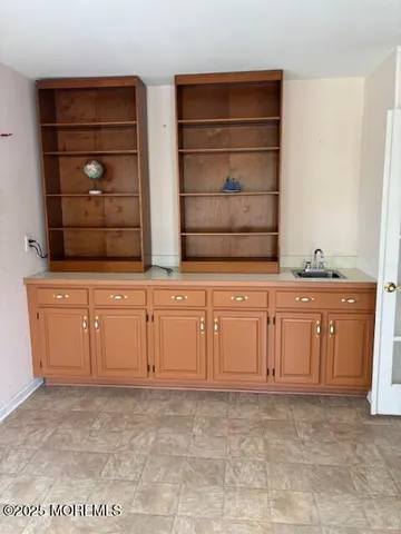 a view of empty room with cabinet and window