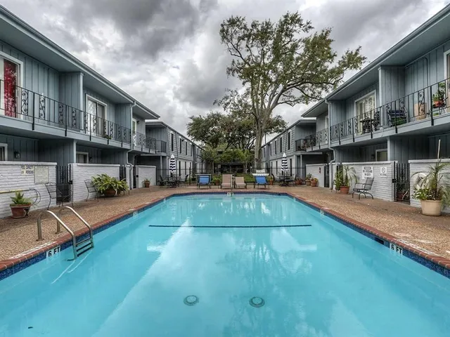 a swimming pool view with a seating space and a garden view